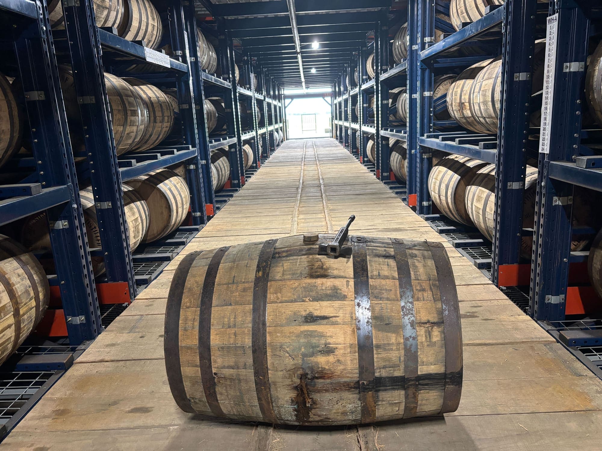 Barrels aging in a rickhouse aisle